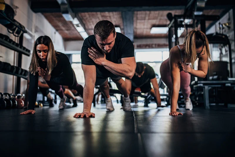 A personal trainer guiding a beginner through strength training exercises.